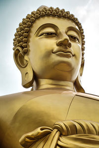 Low angle view of buddha statue against building