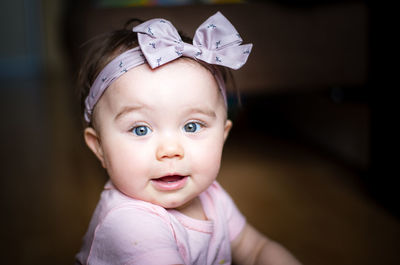 Portrait of cute baby girl wearing headband at home