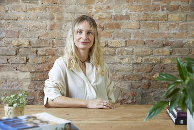 Portrait of young woman sitting on table