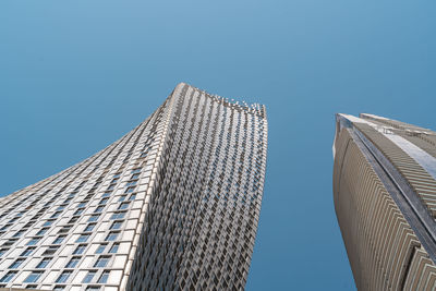 Low angle view of modern buildings against clear blue sky