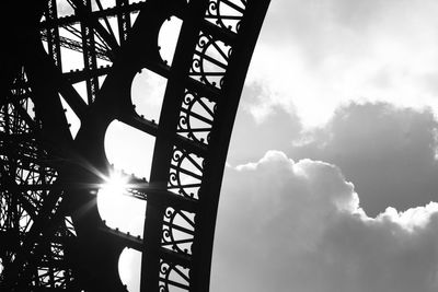 Low angle view of metal structure against cloudy sky