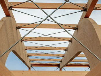 Detail of a modern wooden architecture in glued laminated timber on a blue cloudy sky