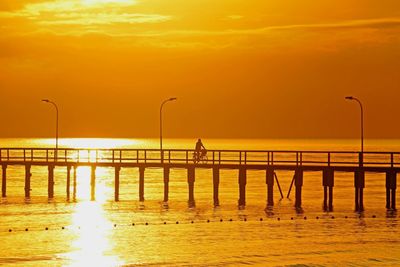 Pier on sea at sunset