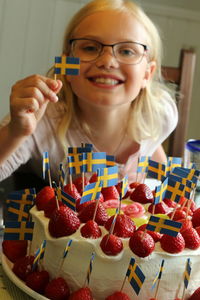 Portrait of girl with cake with swedish flags