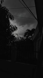 Silhouette tree and house against sky