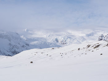 Scenic view of snow covered mountains against sky