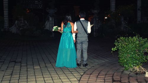 Rear view of bridesmaid and best man with bouquet at wedding