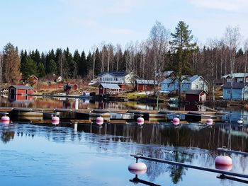 Boats in lake by buildings against sky