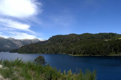 Scenic view of lake and mountains against blue sky