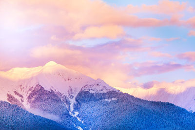 Scenic view of snowcapped mountains against sky during sunset