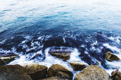 High angle view of water flowing in sea against sky