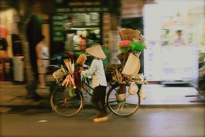 Vendor selling cleaning equipment on bicycle in city