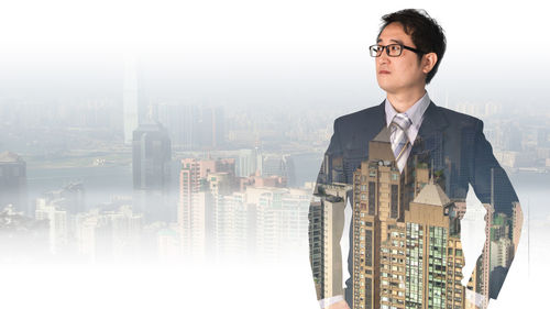 Digital composite image of man and woman standing by buildings in city