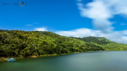 Scenic view of lake by trees against sky