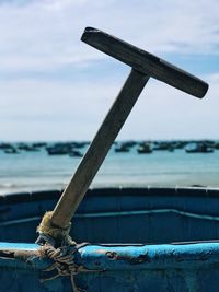 Close-up of tool tied on container against sky