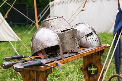 Close-up of medieval helmets and swords on table