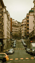 Traffic on road amidst buildings in city against sky