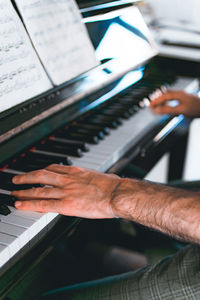 Midsection of man playing piano