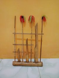 Close-up of paintbrushes on table against wall