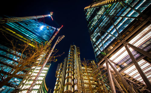 Low angle view of illuminated buildings against sky at night