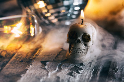 Close-up of skull shaped candle burning on table