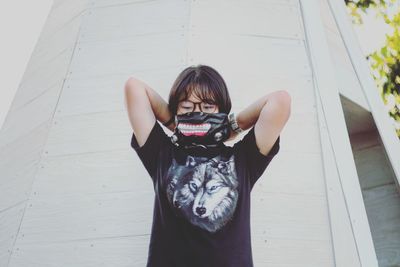 Young woman standing against wall