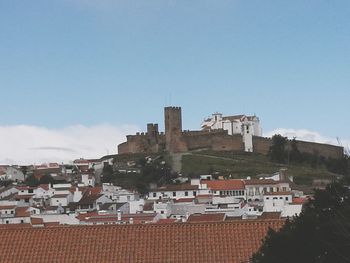 Buildings in city against blue sky