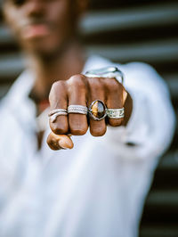 Blurred anonymous african american stylish male showing fist with various trendy silver rings