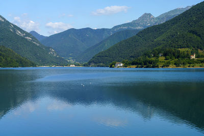 Scenic view of lake by mountains against sky