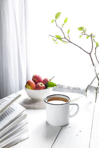 Fruits and coffee in bowl on table
