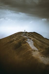 Person on arid landscape against sky