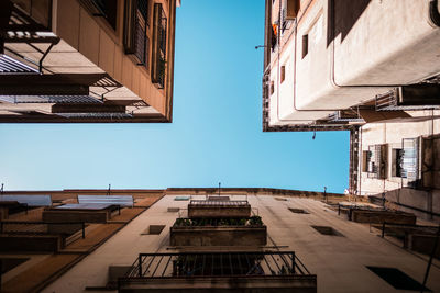 Low angle view of buildings against clear blue sky