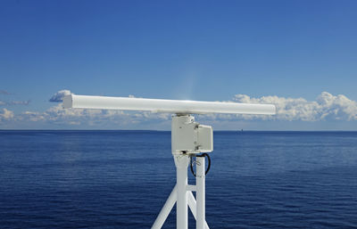 A white rotating radar on a large ship at sea