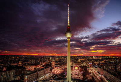 Communications tower and buildings against sky during sunset