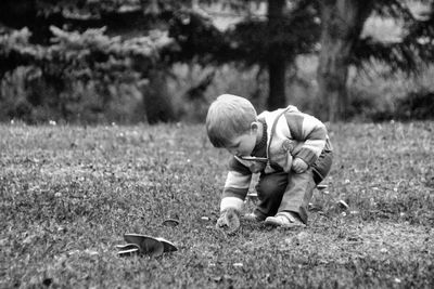 Boy picking fungus on field
