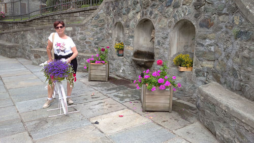 Full length of woman with flower bouquet against temple