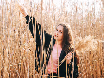 Beautiful young woman standing in field