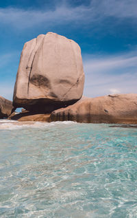 Rock formation in sea against sky