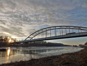 View of bridge over river against cloudy sky