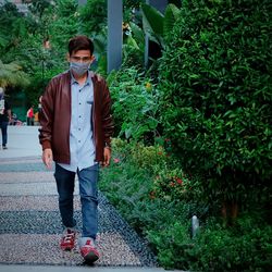 Portrait of man standing on footpath