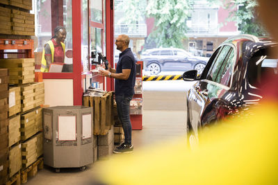 Side view of customer talking to sales staff while standing near checkout counter