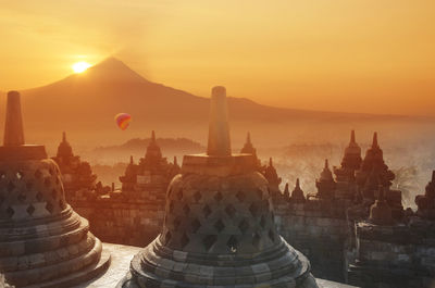 Temple against buildings at sunset