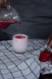 Close-up of hand holding ice cream on table