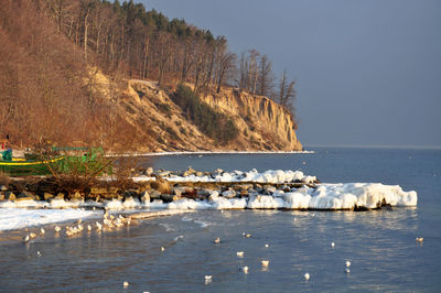 Scenic view of sea and mountains against sky