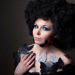 Portrait of young woman against black background