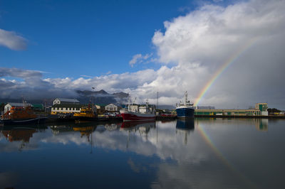 Boats moored at harbor against sky