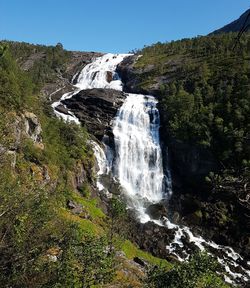 Low angle view of waterfall against clear sky