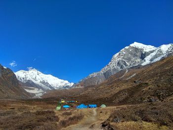 Scenic view of snowcapped mountains against blue sky