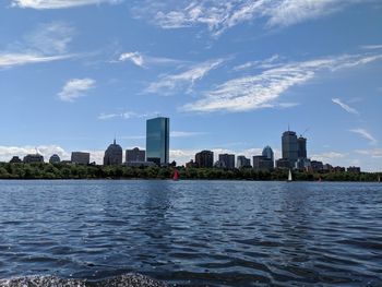 River by buildings in city against sky