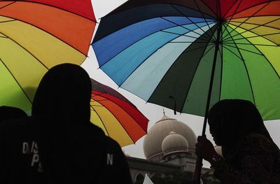 Low angle view of people in umbrella